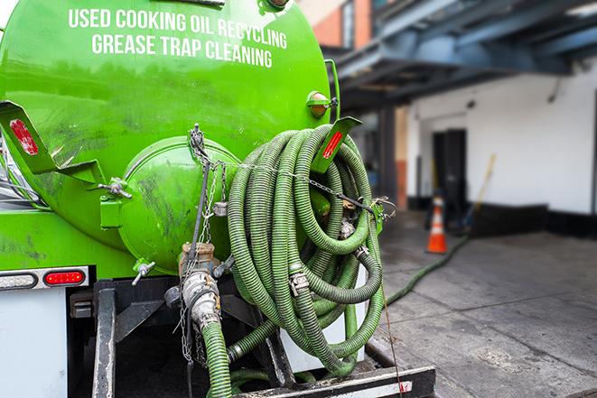 large truck pumping grease trap at a restaurant in Bingham Farms, MI